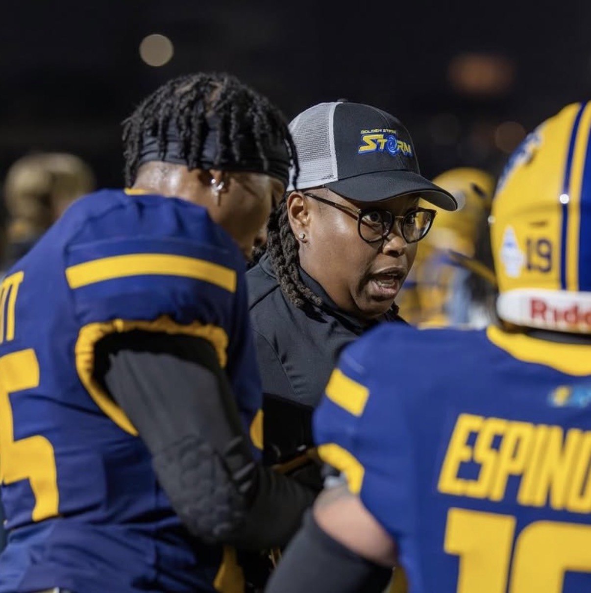 Bennett, left, in the Storm huddle listening to a coach on the sideline at night