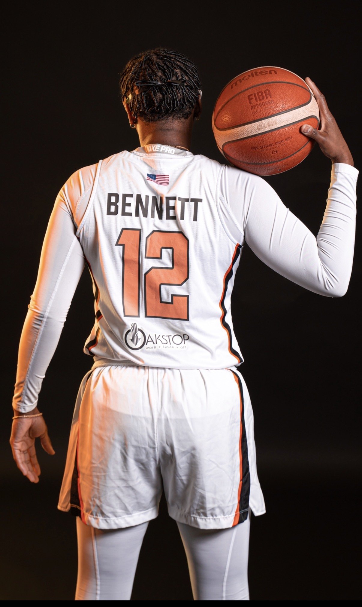 Bennett in her professional basketball kit, number 12, holding a FIBA match ball