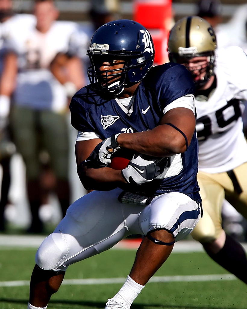 A running back breaking through a tackle